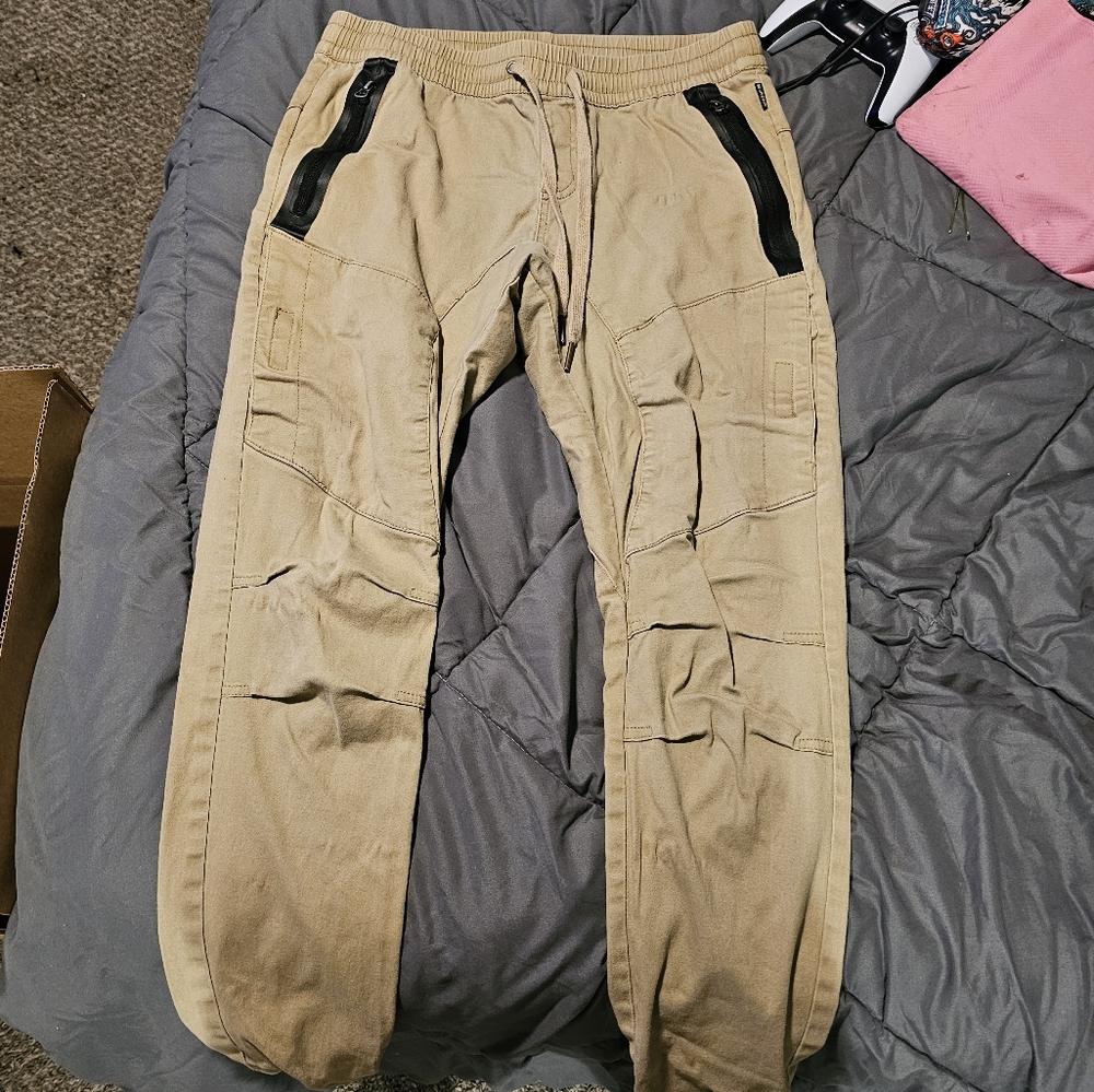 Tan cargo pants with black zippers
